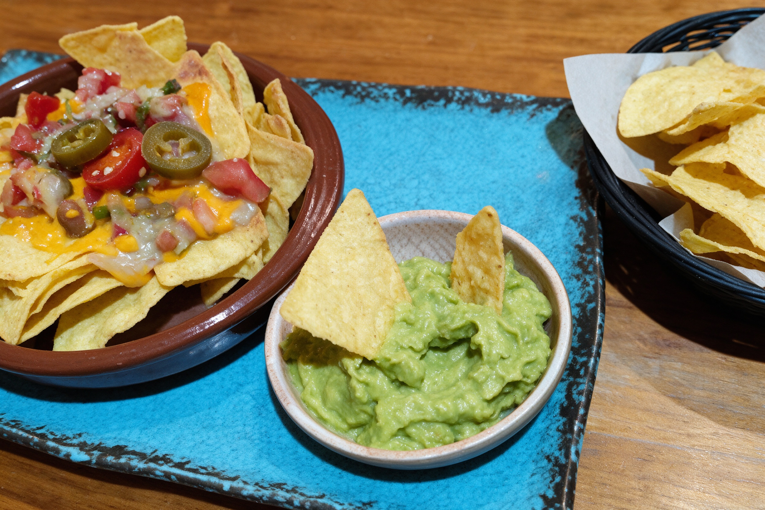 Nachos con queso fundido, salsa de tomate y guacamole